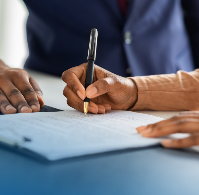 Three people signing paperwork.